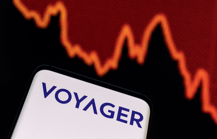 A phone with the Voyager app in front of a declining graph
